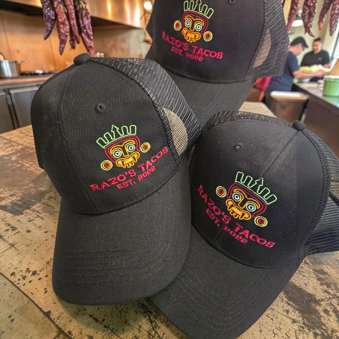 Three black trucker hats with the Razo's Tacos logo
